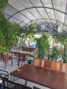 un patio con tavoli, sedie e piante in legno di สวนชะลอม a Ban Ton Chuak