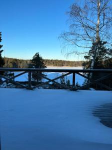 eine Brücke über einen schneebedeckten Fluss mit einem Baum in der Unterkunft Värmdö in Värmdö