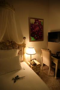 a bedroom with a bed with a lamp and a desk at La Perla Boutique Hotel in İskenderun