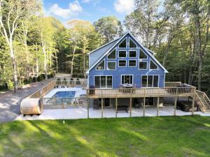 a large blue house with a pool on a deck at Dulce Retreat in Blakeslee