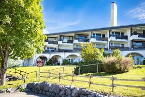 Ein weißes Gebäude mit einem Zaun davor. in der Unterkunft RELAX - GREEN mit Pool und Sauna in Scheidegg