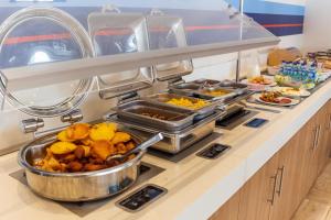 un buffet con muchos platos de comida en una barra en Holiday Inn Express Cartagena Manga, an IHG Hotel, en Cartagena de Indias