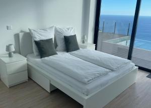 sypialnia z łóżkiem i widokiem na ocean w obiekcie Villa Sea View w mieście Arco da Calheta +28 zdjęć