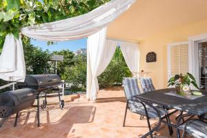 d'une terrasse avec un grill, une table et des chaises. dans l'établissement Ferienhaus für 6 Personen ca 105 qm in Orebić, Dalmatien Süddalmatien, à Orebić