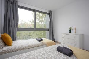 a bedroom with two beds and a large window at Three bedroom Two bathroom apartment Close to Beach in Barcelona