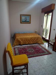 1 dormitorio con 1 cama, 1 silla y 1 alfombra en Torre Adelasia, en Aidone