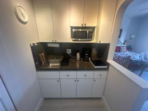 a small kitchen with a sink and a microwave at Dream Studio on the Beach in Miami Beach