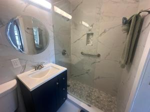 a bathroom with a shower with a sink and a mirror at Dream Studio on the Beach in Miami Beach +15 photos