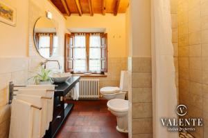 uma casa de banho com 2 WC, um lavatório e um espelho. em Casa con vista panoramica, Matraia, Lucca em Matraia