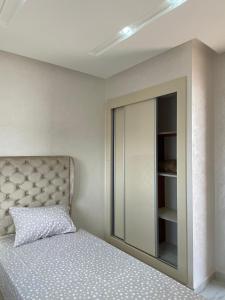 胡塞馬的住宿－Mini villa Al hoceima，一间卧室配有一张床和一个带镜子的橱柜