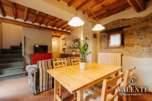 uma sala de jantar e sala de estar com mesa e cadeiras em Casa con vista panoramica, Matraia, Lucca em Matraia