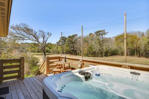 Una bañera en una terraza con vista a un patio. en Kitty Hawk Apartment with Hot Tub - 1 Mi to Beach!, en Kitty Hawk