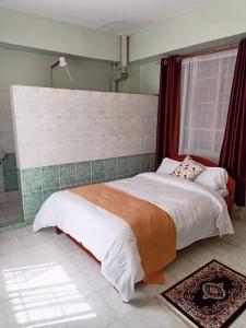 1 dormitorio con 1 cama grande y ventana en Sislink Suites, en Nairobi
