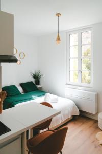 een witte slaapkamer met een bed en een bureau bij ô Quai St Pierre in Toulouse