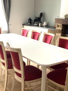 una mesa blanca y sillas en una habitación en La demeure romantique, en Bazouges-sous-Hédé