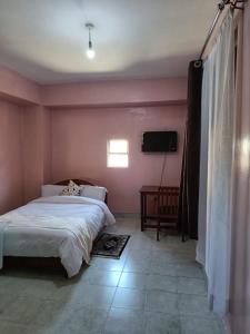 1 dormitorio con 1 cama y TV en Sislink Suites en Nairobi