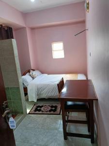 1 dormitorio con cama, escritorio y mesa en Sislink Suites en Nairobi