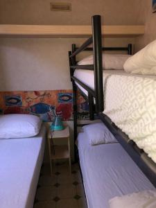 Zimmer mit 3 Etagenbetten und einem Tisch in der Unterkunft Toskana, Viareggio, Chalet Zona Rosa 1 in Viareggio