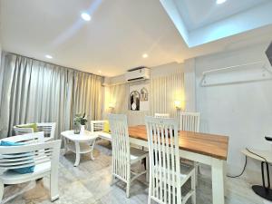 a dining room with a table and white chairs at 39 Living Pattaya in Pattaya Central