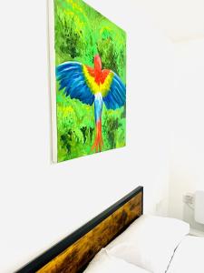 a painting of a tropical bird on a wall above a bed at Albert Inn Apartments in Manchester