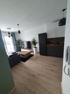 a living room with a couch and a kitchen at Apartament Number 2 NOVA WOZOWNIA Free Parking in Leszno
