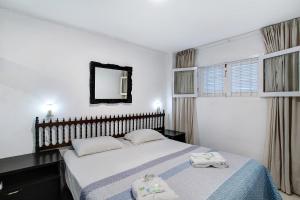 Un dormitorio con una cama con dos toallas encima. en Los Molinos 538, en Maspalomas