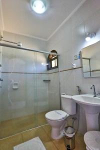 a bathroom with a shower and a toilet and a sink at Hotel Fazenda Village Montana in Socorro