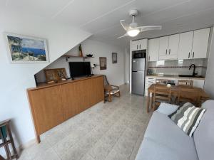 a living room with a couch and a kitchen at La Vall - Apartamento en planta baja con piscina in Cala en Blanes