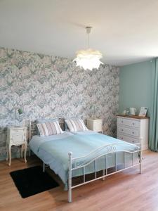 una camera da letto con un letto con una parete con accenti floreali di Le Verger du Paradis a Beaulieu-sur-Sonnette