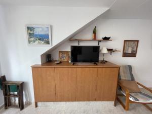 a living room with a tv on a wooden dresser at La Vall - Apartamento en planta baja con piscina in Cala en Blanes