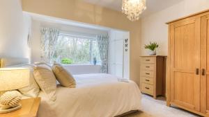 a bedroom with a white bed and a window at Gamdda Fawr in Llanallgo +69 photos