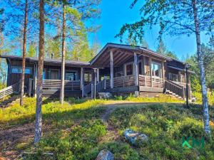 una gran cabaña de madera en el bosque con un patio en Villa Kolovesi - Saimaa Retreat en Savonlinna