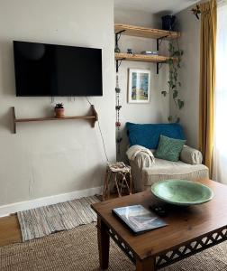 a living room with a couch and a table at Cottage Hideaway with Garden in Bristol