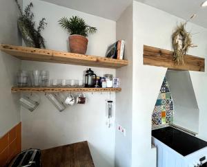 a kitchen with wooden shelves on the wall at Cottage Hideaway with Garden in Bristol