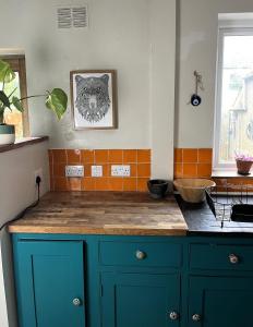 a kitchen with blue cabinets and a counter top at Cottage Hideaway with Garden in Bristol
