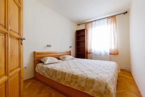 a bedroom with a bed and a window at Bíbor Apartment in Budapest