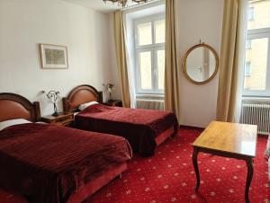 a hotel room with two beds and a mirror at Mariahilf Citycenter Hotel in Vienna