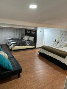 1 dormitorio con 2 camas y sofá en Escape de altura, en San Luis Río Colorado