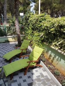 Duas espreguiçadeiras verdes sentadas num pátio em Ferienwohnung für 4 Personen ca 35 qm in Pula, Istrien Istrische Riviera em Pula