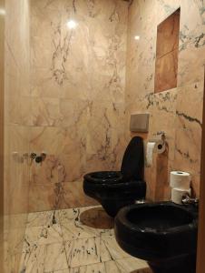 a bathroom with a black toilet and a marble wall at Mariahilf Citycenter Hotel in Vienna