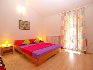 een slaapkamer met een bed met rode lakens en groene kussens bij Ferienwohnung für 5 Personen ca 70 qm in Pula, Istrien Istrische Riviera - b60851 in Pula