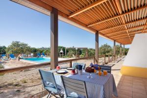 un patio con mesa, sillas y piscina en Quinta Tapada dos Machados en Alvor