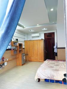1 dormitorio con 1 cama y armarios de madera en My home your home en Ho Chi Minh