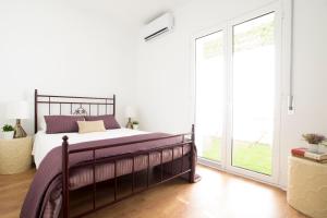 um quarto com uma cama e uma grande janela em Fabulous Apartment at UNESCO World Heritage Center em Coimbra