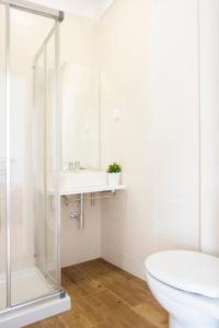 uma casa de banho com um chuveiro, um lavatório e um WC. em Fabulous Apartment at UNESCO World Heritage Center em Coimbra