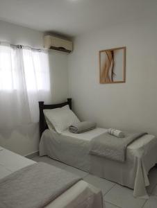 Belo JardimにあるBOI NA BRASA - BELO JARDIMの白い部屋(ベッド2台、鏡付)