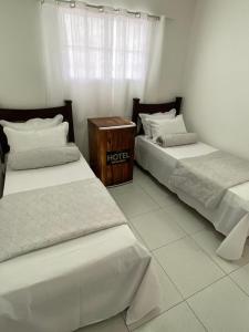 Belo JardimにあるBOI NA BRASA - BELO JARDIMのベッド2台が隣同士に設置された部屋です。