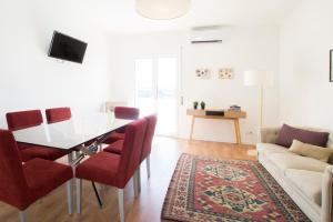 uma sala de estar com uma mesa de jantar e cadeiras vermelhas em Fabulous Apartment at UNESCO World Heritage Center em Coimbra