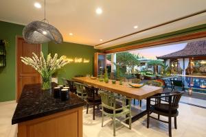 a dining room with a long wooden table and chairs at ATLAS XXL BEACH BOUTIQUE VILLA Fully Staffed Daily Breakfast Walking Distance to Berawa Beach in Canggu