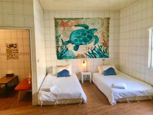 um quarto com duas camas e um quadro na parede em Liuqiu Cozy Room em Xiaoliuqiu